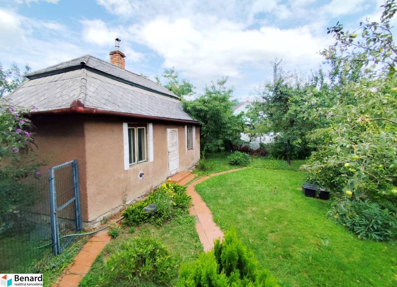 A family house in the town of Veľký Šariš surrounded by a garden and greenery.