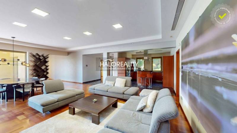 A spacious living room with a comfortable sofa set and a dining table in a family house.