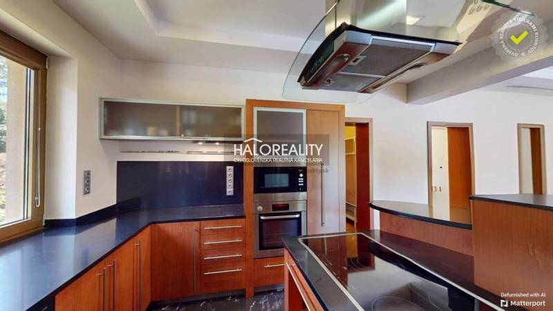 A modern kitchen with wooden elements and a large window in a family house.