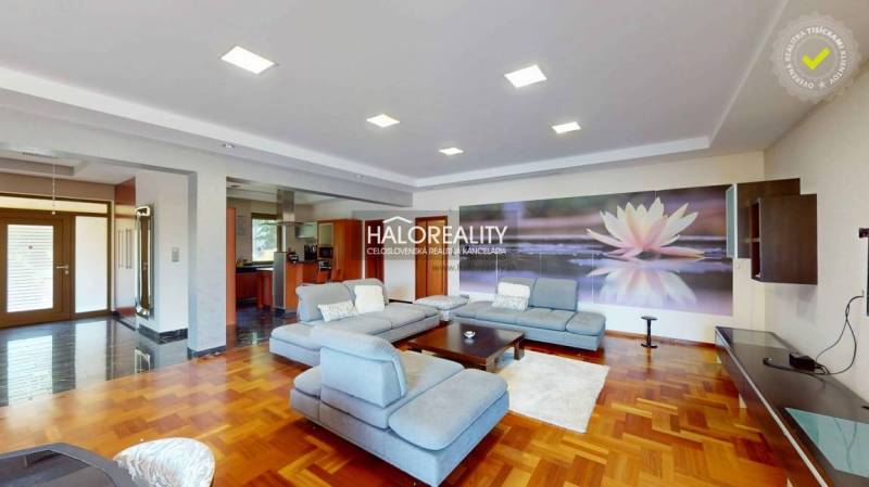 Living room in a family house with a large sofa and a floral painting on the wall.