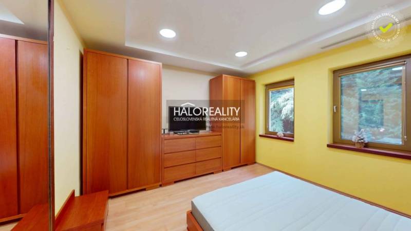 Yellow bedroom with a wooden wardrobe and windows in a family house.