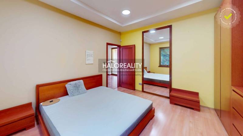 A bedroom in a family house with a large mirror and wooden furniture.