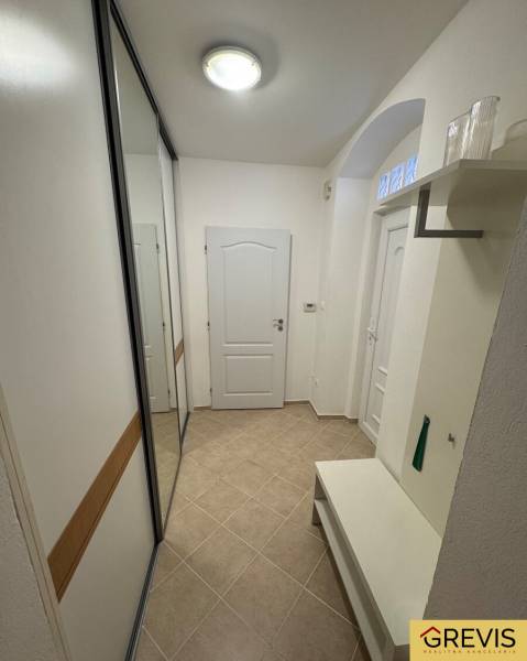 A bright hallway with tiles, a built-in wardrobe, and a bench in a 2-room apartment.