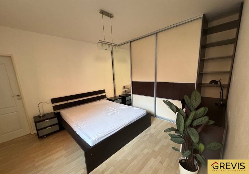 Bedroom with a built-in wardrobe, bed, and nightstands in a two-room apartment.