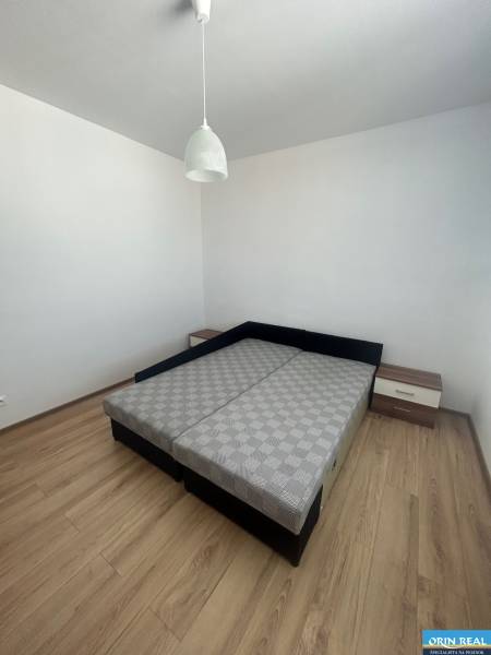 Bedroom in a 3-room apartment with a bed, nightstands, and a hanging light fixture.