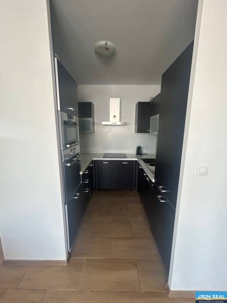 A kitchen in a 3-room apartment with dark cabinets and built-in appliances.