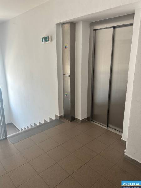 Staircase and elevator in a 3-room apartment, clean spaces with tiles.