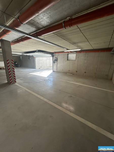 Parking space in the underground garage of a 3-room apartment, with an access ramp.
