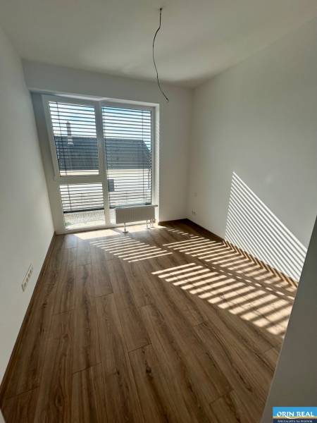 A room in a 3-room apartment with laminate flooring and a large window.