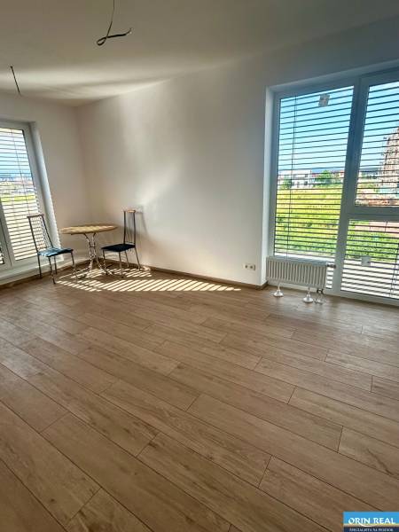 A room in a 3-room apartment with a wooden floor and two windows with a view.