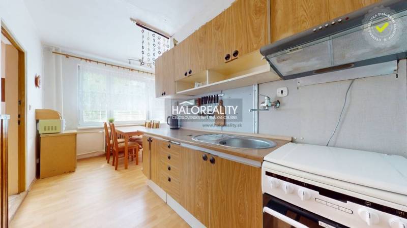 A kitchen with a dining table and appliances in a 4-room apartment.