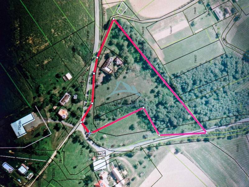 An aerial photograph shows a construction site bordered by a line, near family houses.