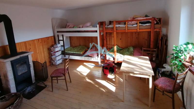 Bunk beds, wood-burning stove, and furniture in the room in a family house.