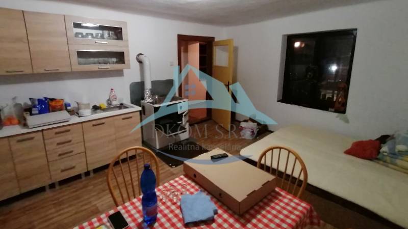 A kitchen with a stove, dining table, and bed, suitable for a family house.