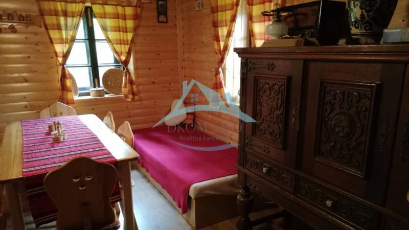 The interior of a log cabin with solid furniture, wooden walls, and colorful curtains in a family house.