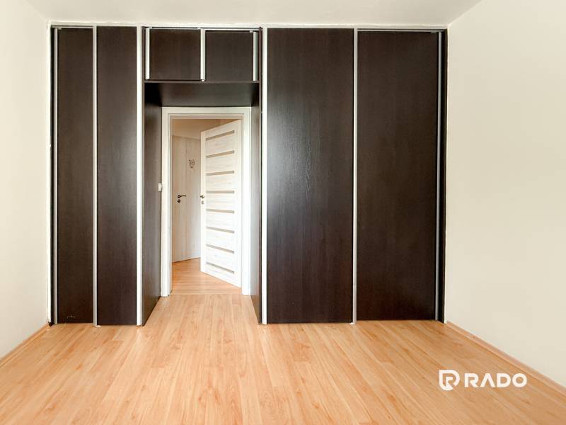 In the 3-room apartment, you can see a built-in wardrobe with dark doors and a wooden floor.