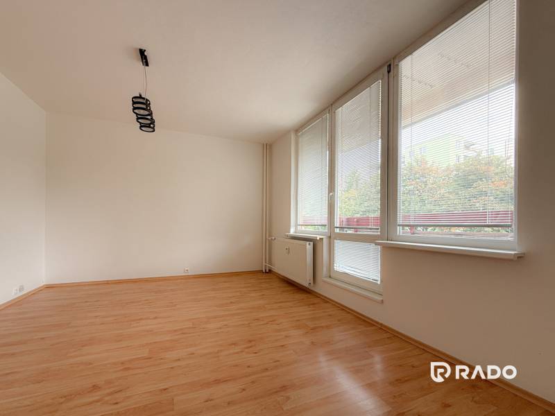 A spacious room with large windows and laminate flooring in a 3-room apartment.