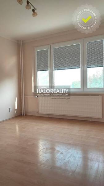 A room in a 4-room apartment with wooden flooring and a large window.