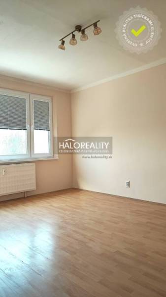 A bright interior of a 4-room apartment with laminate flooring and a large window.