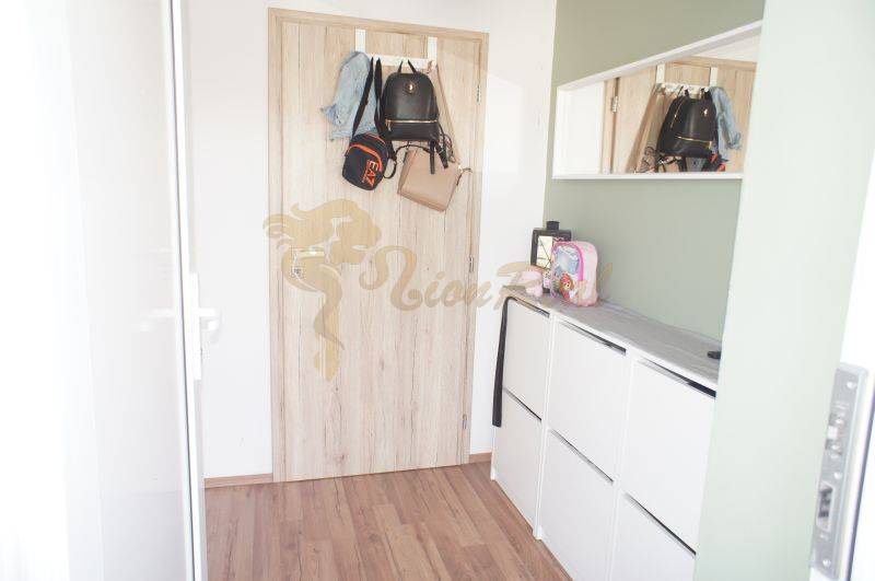 A hallway in a family house with wooden doors and white furniture.