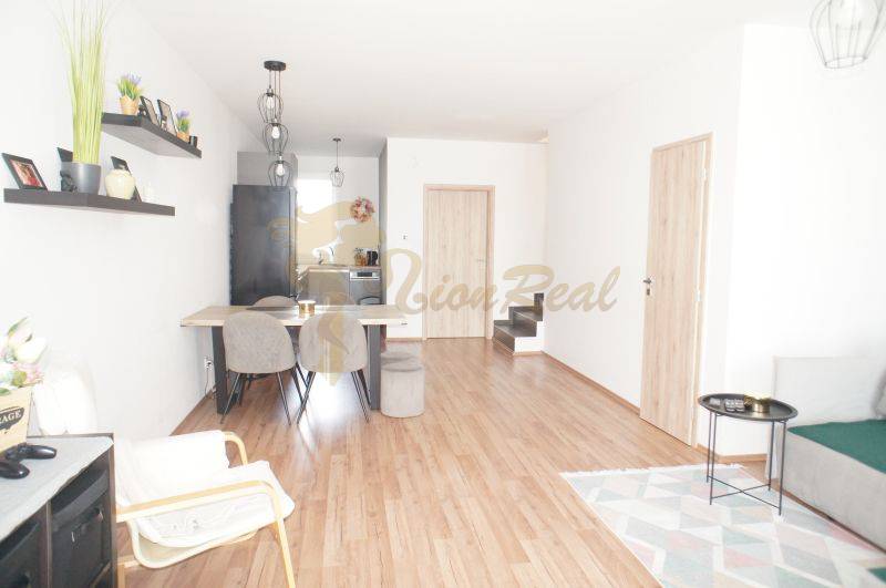 Living room in a family house with wooden flooring and light furniture.