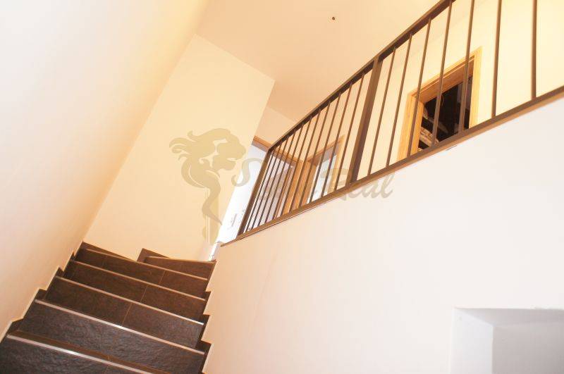 A staircase with a metal railing in a family house, simple interior design.