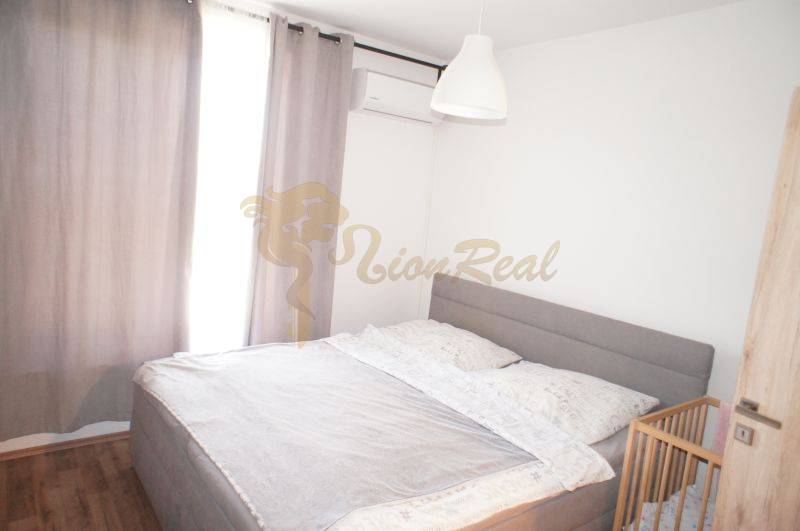 Bedroom in a family house with a large bed, air conditioning, and a baby crib.