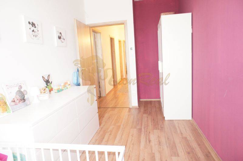 A children's room in a family house with a wooden floor and a purple wall.