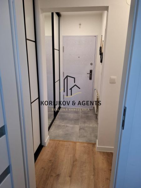 Entrance hallway of a 2-room apartment with tiles and wood-patterned flooring.