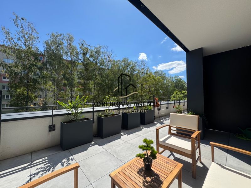 Terrace of a 1-room apartment with a view of Popradská Street in Košice, surrounded by greenery.