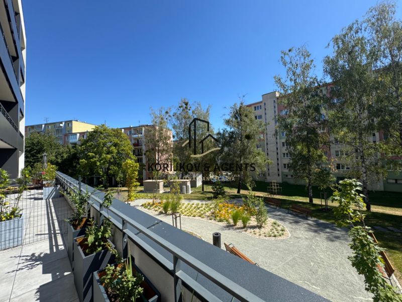 View of greenery and apartment buildings from the balcony on Popradská Street in Košice.