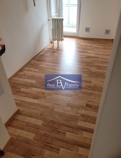A room with a wooden floor and a radiator in a 3-room apartment.