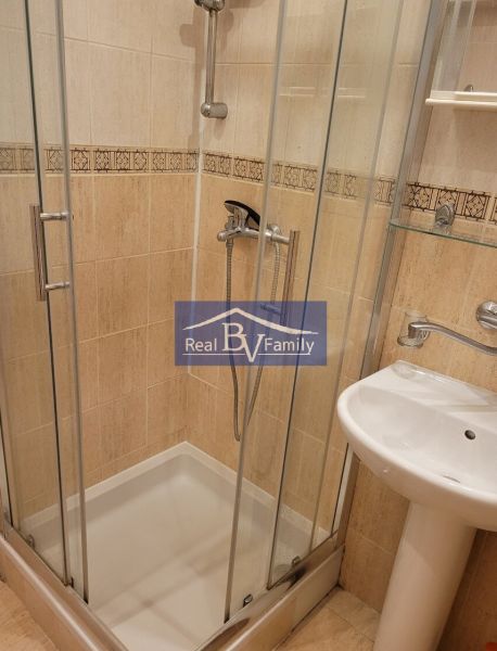Shower enclosure with glass doors and a sink in the bathroom of a 3-room apartment.