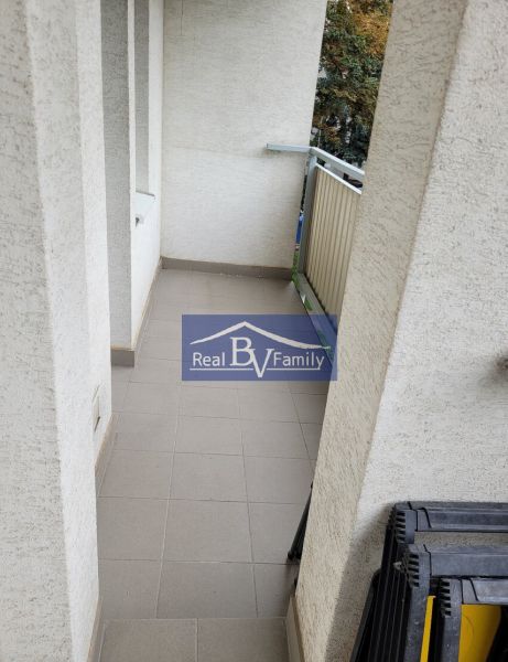 A balcony in a 3-room apartment with tiles and a railing.