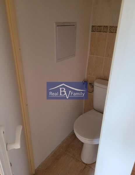 Toilet in a 3-room apartment, light-colored tiles and wall tiles.