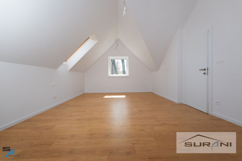 Attic room with wood-patterned flooring in a family house.