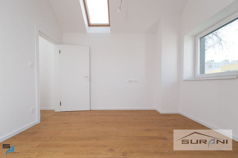 A room in a family house with a wooden decor floor and a skylight.