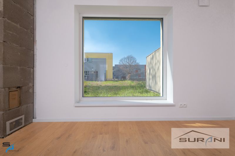 Interior of a family house with a large window and a wooden decor floor.