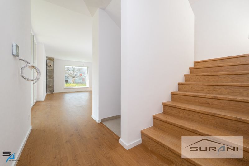 Staircase and room with a large window, wooden decor flooring in a family house.