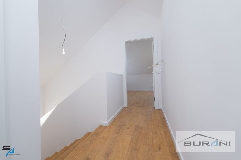 Interior of a family house with white walls and a floor with a wood decor.
