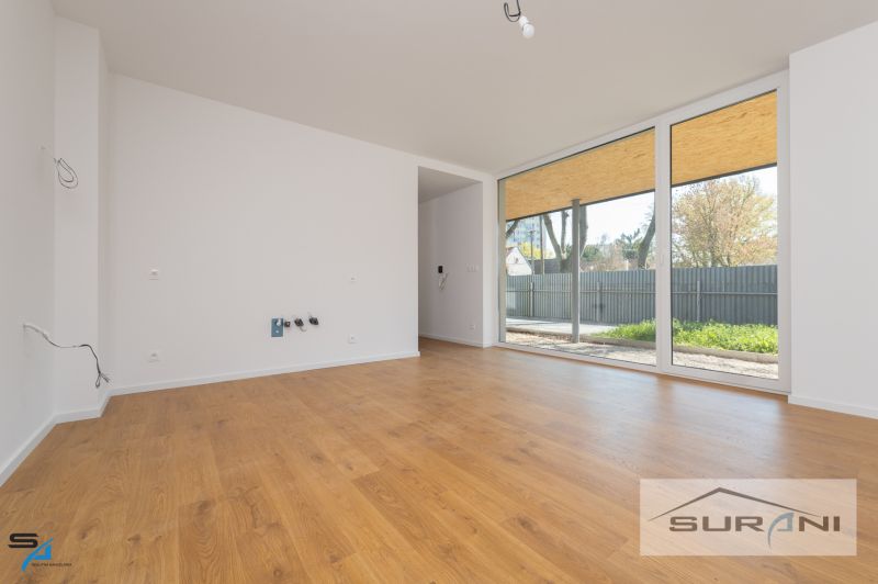 A room in a family house with large windows and a wooden decor floor.