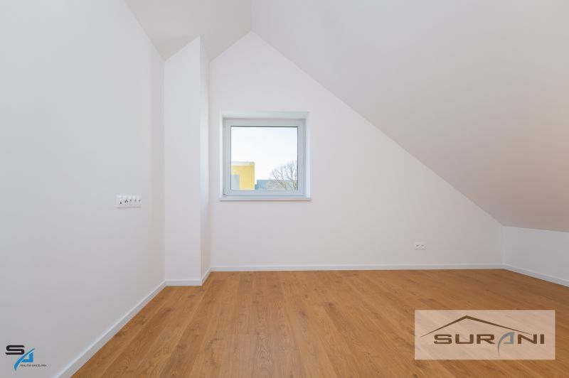 Attic room with a window and a wooden decor floor in a family house.