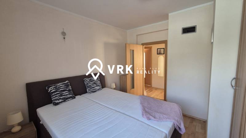 Bedroom in a family house with a double bed, nightstands, and a wooden-decor floor.