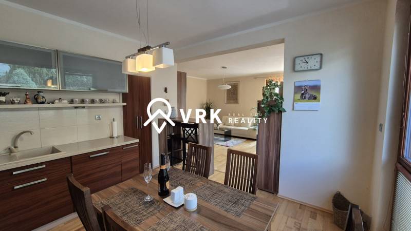 Interior of a family house with a kitchen, dining table, and floor with wood decor.