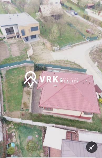 A family house in Ličartovce with a red roof, a garden, and a nearby access road.