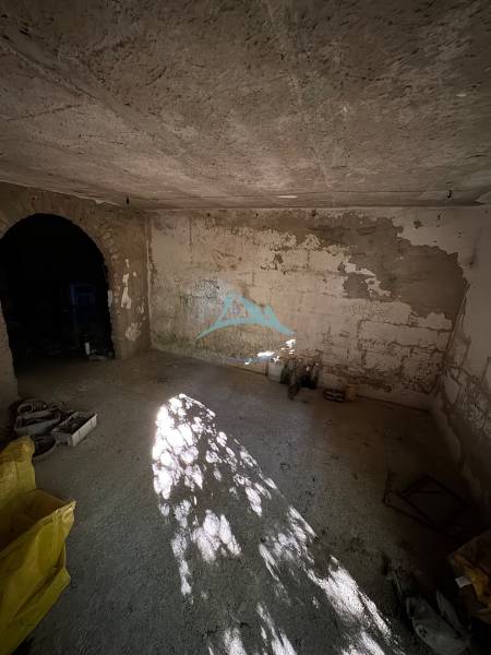 An empty room with a raw concrete floor and ceiling in a cabin in Veľké Turovce.