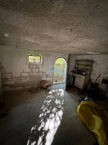 Abandoned room in a cabin with open doors and old furniture.