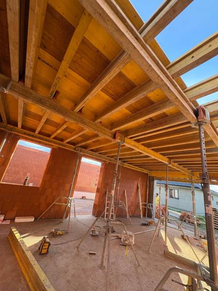 Construction of houses in Ľubotice with wooden beams and brick walls.