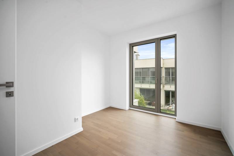 A room with a wooden floor decor and a large window in a 4-room apartment.
