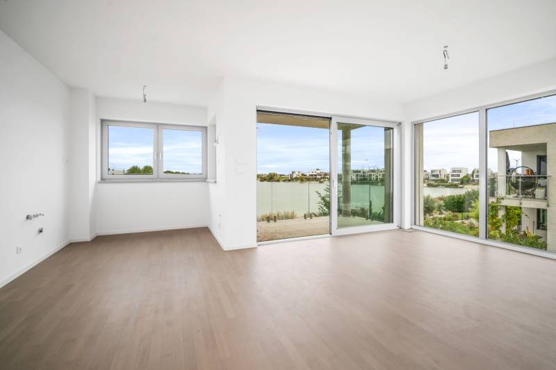 A bright room with a glass wall and a wooden decor floor in a four-room apartment.